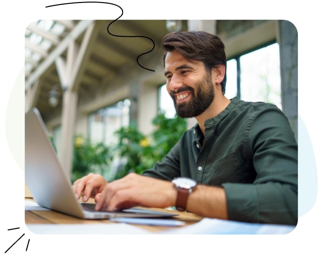 Un homme assis à un bureau, travaillant sur un ordinateur portable.